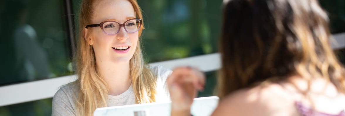 Two ASU students sitting at a table outside