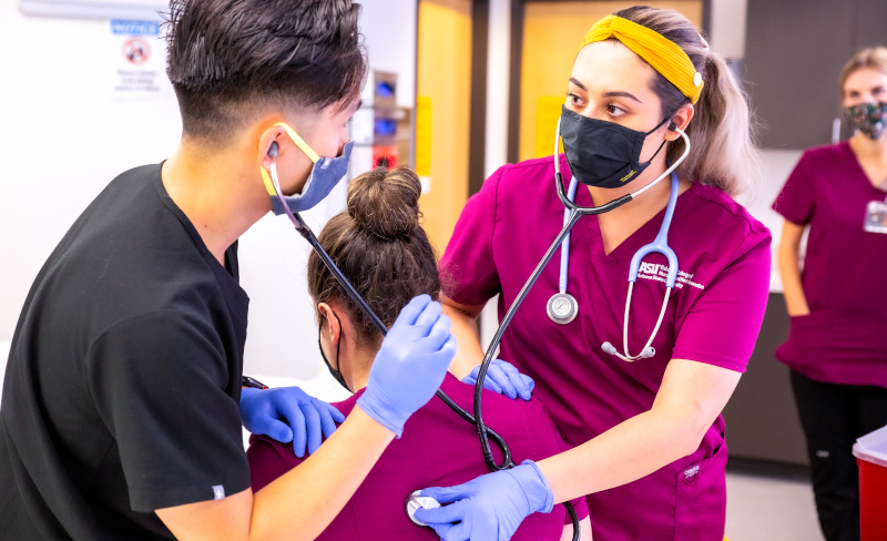 Medical students listening to a patient breathing