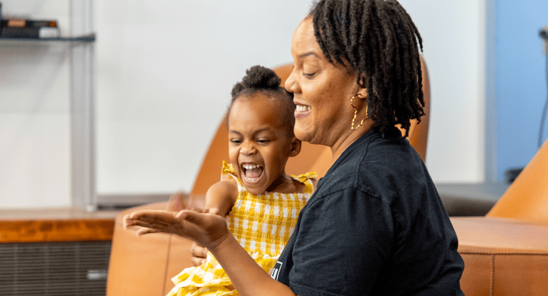 Woman and a young girl giving each other a high five