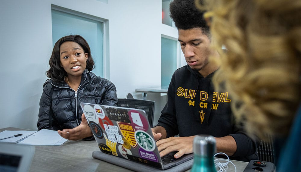 ASU students sitting at a table and talking