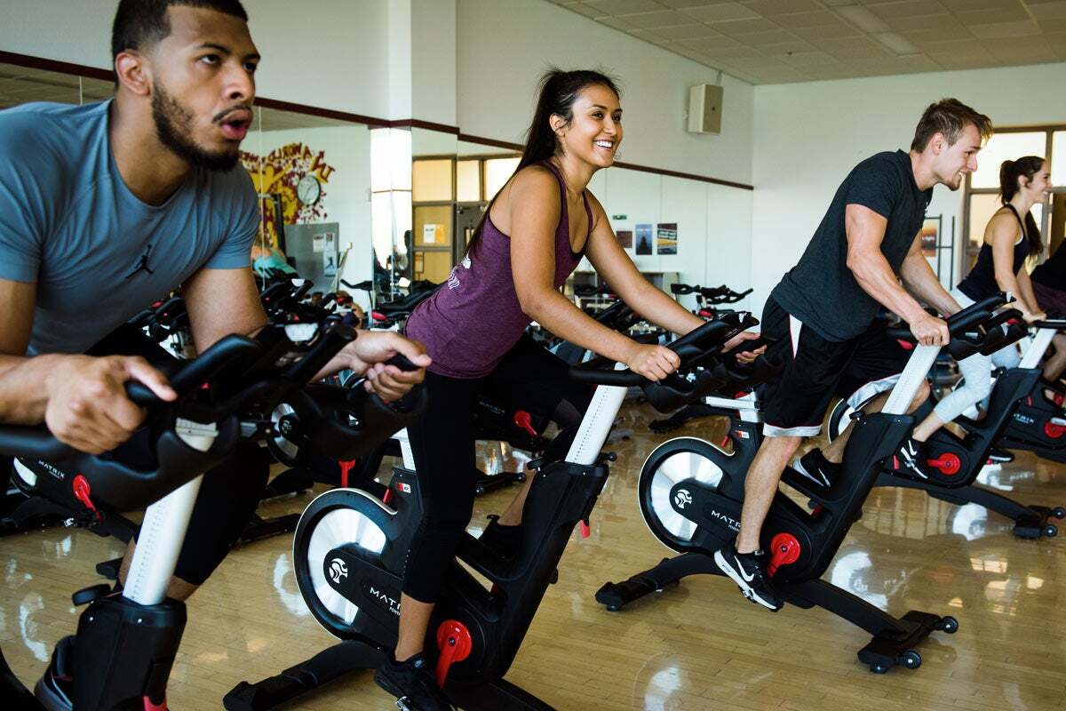 Young people working out in a cycling class