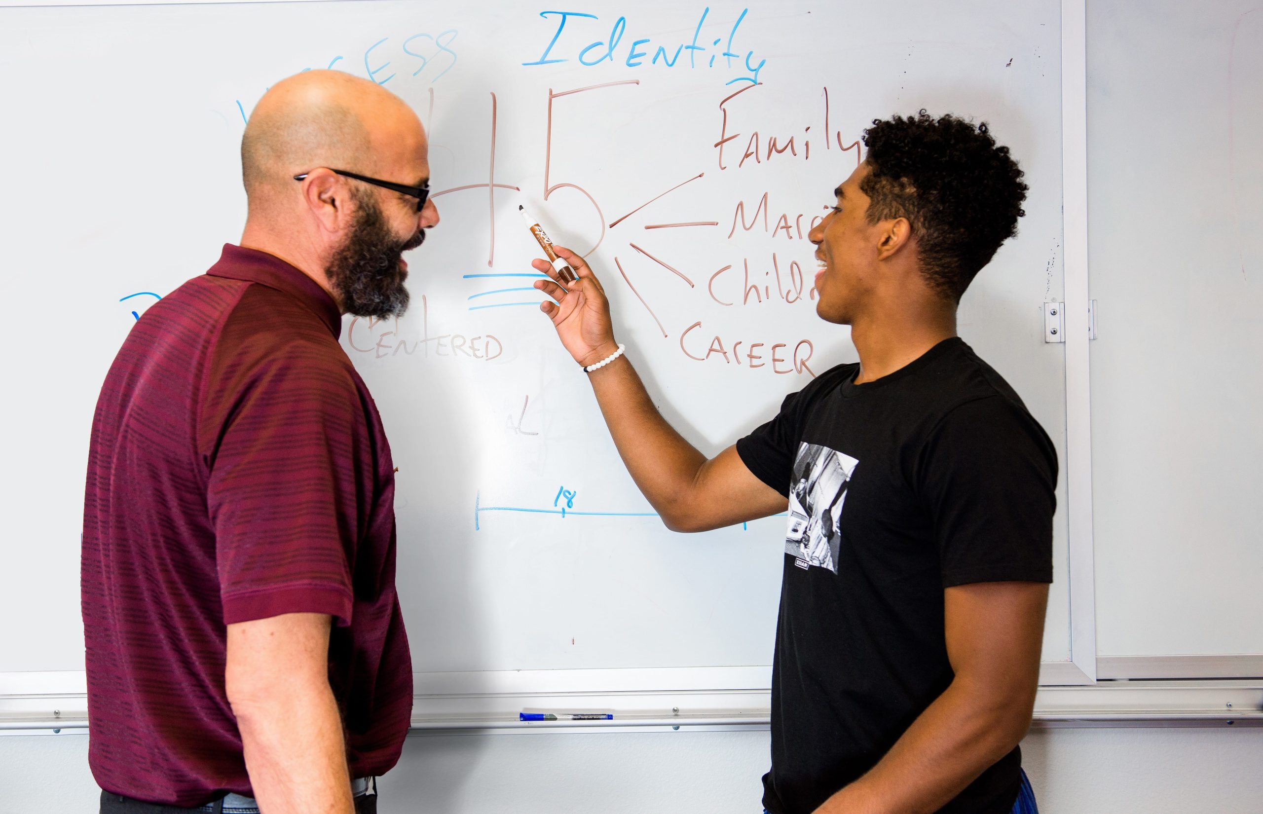 Student and professor working together on a white board