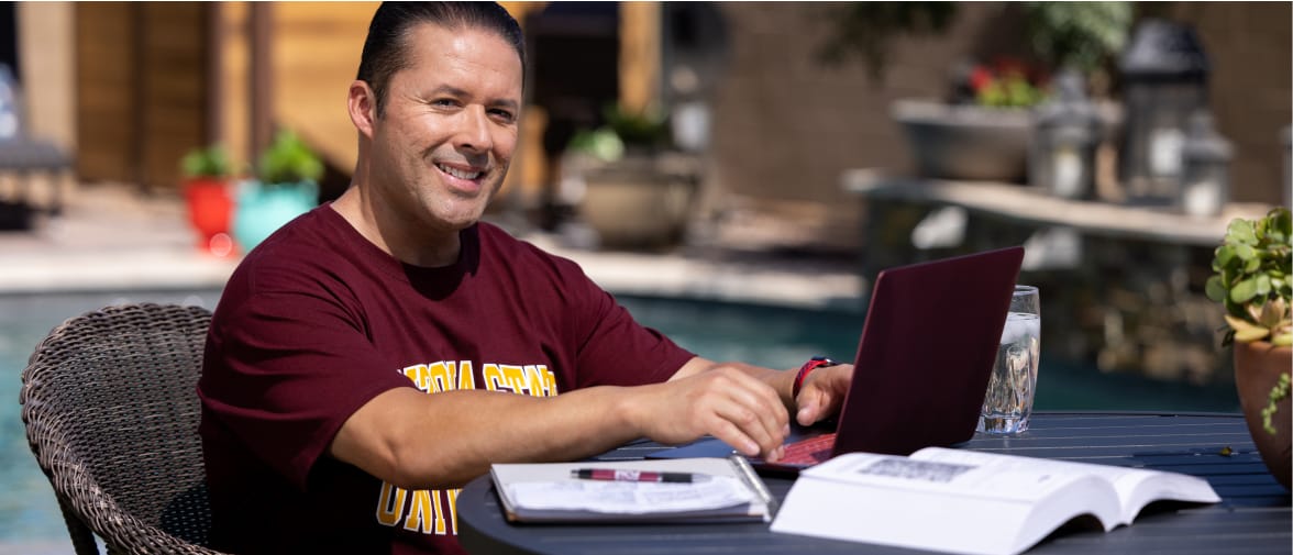 Man studying outside with ASU shirt